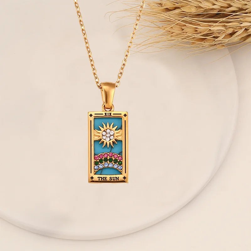 AuraTemple gold stainless steel necklace featuring a rectangular pendant with a turquoise inlay depicting The Sun tarot card, adorned with cubic zirconia.