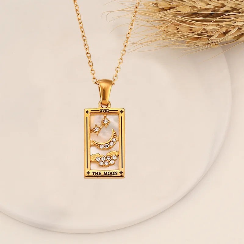 AuraTemple gold stainless steel necklace featuring a rectangular pendant with a "The Moon" tarot card design, inlaid with mother-of-pearl, cubic zirconia stars, and a crescent moon.