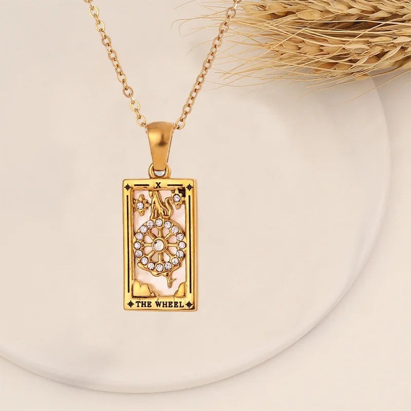 AuraTemple gold stainless steel necklace with a rectangular pendant featuring a Tarot 'The Wheel' card design, adorned with cubic zirconia.